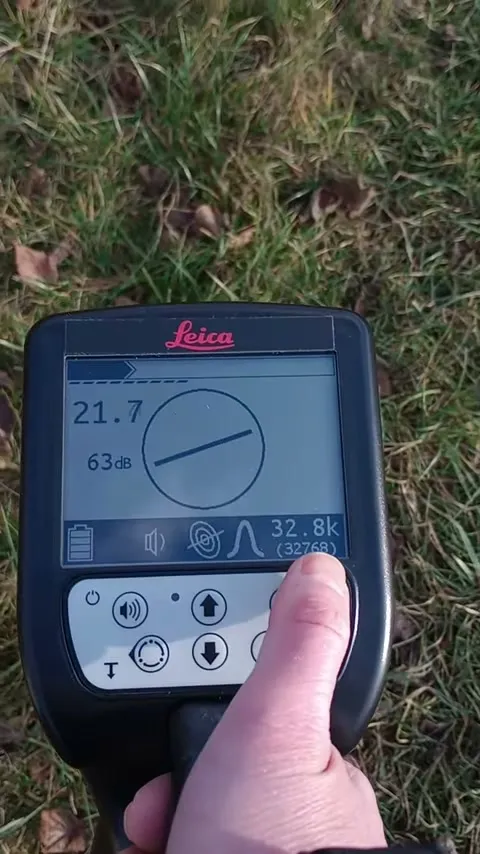 Lokalizator Leica Ultra w dłoni nad trawnikiem